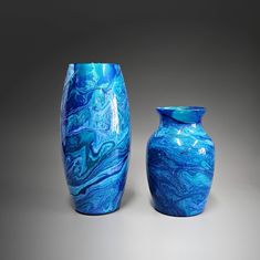 Flowers don't last; hand painted vases do. Either one of these abstract, glass flower vases makes the perfect accent piece for any décor. Unique and one-of-a-kind, you're sure to get many compliments on this stand-out piece of art. Done in a striking mix of shaded blues and aqua, it was hand painted with acrylics, then sealed with multiple coats of high gloss varnish. Some of the paints have a metallic sheen adding a touch of shimmer to each vase. Make it functional art by adding a fresh bouquet Flower Vase Making, Painted Glass Vases, Painted Glass Art, Glass Flower Vases, Green Glass Vase, Hand Painted Vases, Statement Art, Painted Vases, Acrylic Pour