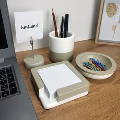 a desk with a laptop, pen holder and other office supplies