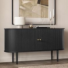 a black and gold sideboard in a living room with a painting on the wall