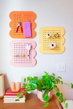 a desk with two pegboards and a potted plant next to it on top of a wooden table