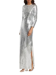 The Markarian Gianna Column gown shines brilliantly with its all-over silvertone sequin embellishments and sophisticated long sleeve design. Crewneck Long sleeves Concealed back zip closure 69% polyester/21% nylon/10% polyester Lining: 100% silk Dry clean Made in USA of Italian fabric SIZE  FIT Model measuremnets: 5'10 tall Model is wearing a US size 4 Evening Gown With Sequins, Full Length, Glamorous Sequin Fabric For Formal Gala, Evening Gown With Contrast Sequins For Formal Occasions, Evening Gown With Contrast Sequin For Formal Events, Evening Formal Gown With Contrast Sequin, Fitted Shimmer Gown For Evening, Glamorous Holiday Sequin Fabric For Formal Occasions, Elegant Floor-length Sequin Fabric For Formal Occasions, Fitted Sequin Fabric For Formal Gala