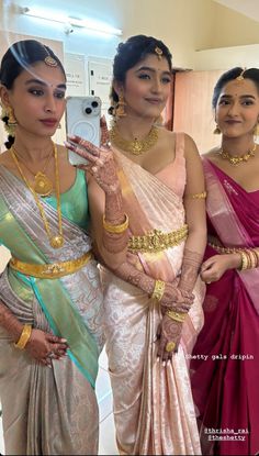 three women in sari are taking a selfie