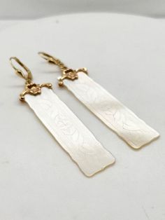 Chinese gaming counters became incredibly popular in the late 1800's and were often adorned with hand carved family crests or initials.  These beautiful counters are made from Mother of Pearl and are etched with delicate floral patterns and set on custom 14k yellow gold bails.  Lever back closures gives additional security as well as nice movement with these delicate dangle earrings! Elegant Carved Earrings For Formal Occasions, Elegant Carved Drop Earrings, Victorian Hallmarked Earrings For Ceremonial Occasions, Vintage Engraved Earrings For Wedding, Vintage Wedding Earrings Engraved, Antique Engraved Drop Earrings, Elegant Carved Yellow Gold Earrings, Victorian 14k Gold Earrings, Antique Filigree Earrings For Ceremonial Occasions