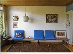 a living room filled with blue chairs and a rug on top of a hard wood floor