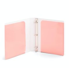 a pink binder is open on top of a white book with two pages in it