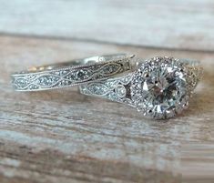 two wedding rings on top of each other with an old - fashioned style diamond in the center