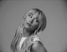 a black and white photo of a woman with long blonde hair wearing large hoop earrings