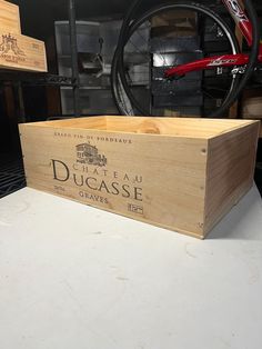 a wooden box sitting on top of a white counter next to a bicycle tire rack