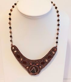 The large stone in this collar style necklace is a stunning piece of red jasper, and there are further smaller red jasper stones. I have bead embroidered  it with seed beads  in different AB silver lined dark topaz which complements the gemstones. I  added some pretty Keshi pearls which have a lovely sheen. It is finished off with a border of  more  seed beads. It is approx 5.5" / 14 cm  wide and  approx. 2"/ 5 cm long at the front point..  It  is hung on 2 lengths of  linked chain using Jasper Artisan Handmade Jasper Necklaces, Handmade Jasper Elegant Necklace, Unique Handmade Jasper Necklace, Elegant Handmade Jasper Necklaces, Elegant Handmade Jasper Necklace, Handmade Jasper Round Beads Necklaces, Gift Jasper Beaded Necklaces, Elegant Beaded Jasper Necklaces, Elegant Jasper Beaded Necklaces