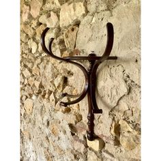 a wrought iron coat rack on a stone wall