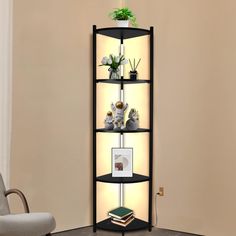 a corner shelf with plants and pictures on it in front of a beige wall next to a chair