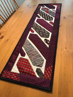 a long table runner with many different patterns on it, sitting on a wooden floor