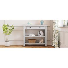 a white table with a shelf on top of it next to a potted plant