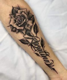 a black and white rose tattoo on the right arm with writing underneath it that says,