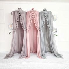 three different colored sheer curtains with flowers on the top one is pink, grey and white