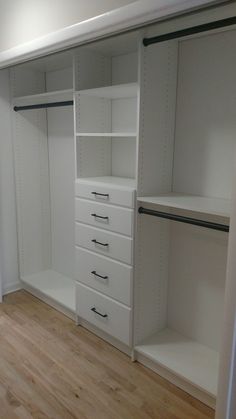 an empty walk in closet with white shelves and drawers