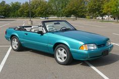 a blue convertible car parked in a parking lot