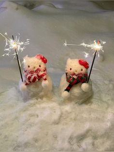 two teddy bears holding sparklers in the snow