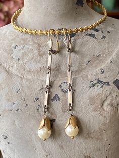 Vintage Glass Ivory Pearl Drop Dangle Earrings  Ivory off white glass Pearls with vintage brass bud-like caps dangle from vintage chain with an engraved look edge. They dangle from antiqued brass lever back ear wires. They measure 2 1/2 inches from top of ear wire.  👑 Matching Necklace: https://www.etsy.com/listing/1020171820/ivory-off-white-glass-pearl-drop?ref=shop_home_active_2&frs=1 👑 More Dangle Earrings: https://www.etsy.com/shop/tinygoldcrowns?ref=seller-platform-mcnav&search_query=Dang Vintage Long Drop Nickel-free Jewelry, Handmade Vintage Long Drop Jewelry, Vintage Pearl Drop Jewelry For Vintage Events, Vintage Pearl Drop Dangle Jewelry, Vintage Cream Pearl Drop Jewelry, Vintage Gold Long Drop Earrings, Jewelry 2024, Vintage Chain, Ivory Pearl