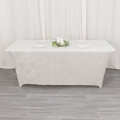 a white table with flowers and candles on it