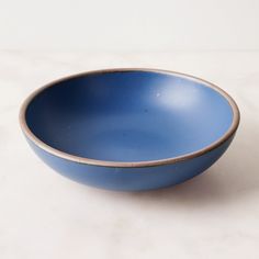 a blue bowl sitting on top of a white counter