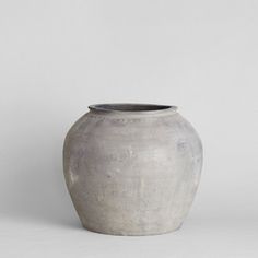 a large gray vase sitting on top of a white table