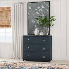 a blue dresser with two drawers and a plant on it in front of a window