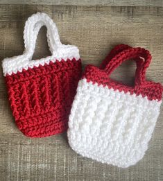 two crocheted purses sitting next to each other on a wooden surface, one is red and the other white