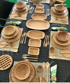 a table set up with bamboo plates and utensils for an outdoor dinner party