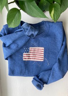 Elegant and Classic Vintage Style American Flag Crewneck Sweater. Please note that sweaters need to be washed once for the fabric will start to fringe. Long Sleeve Americana Sweater For Fall, Americana Long Sleeve Sweater For Fall, Fall Americana Long Sleeve Sweater, Long Sleeve American Style Cotton Sweatshirt, Fall Cotton Sweatshirt With Embroidered Patch, American Style Cotton Long Sleeve Sweatshirt, Winter Cotton Tops With Embroidered Patch, Winter Cotton Top With Embroidered Patch, Patriotic Blue Tops For Fall