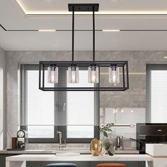 a kitchen island with stools and lights hanging from it's ceiling over the counter