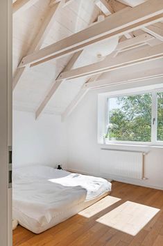 an empty bedroom with wooden floors and white walls