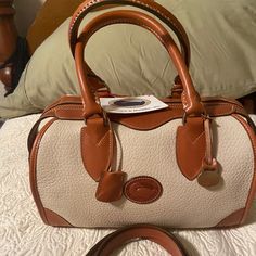 This Dooney And Bourke Gladstone Bag Has Never Been Used It’s Always Been Stored In The Bag It Is Cream Colored With Tan Leather. It’s Beautiful And In Excellent Condition. Bag Is Included Vintage Dooney And Bourke Handbags, Vintage Dooney Bourke Handbags, Gladstone Bag, In The Bag, Dooney And Bourke, Dooney Bourke Handbags, Dooney & Bourke Bags, Dooney & Bourke, Longchamp Le Pliage