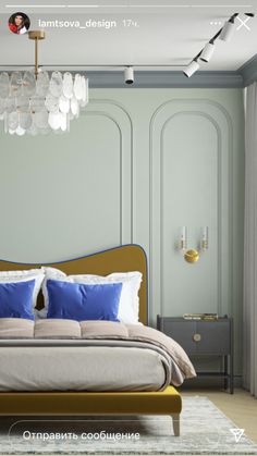 an image of a bedroom setting with blue and white pillows on the bed, chandelier hanging from the ceiling