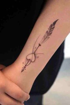 a woman's arm with an arrow tattoo on it