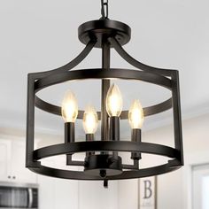 a chandelier with three lights hanging from it's center in a kitchen