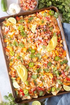 a tray filled with mexican food next to some cilantro and lime wedges