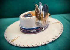 New to Rodeochics is Buffalo Gal-a custom hat accented with a land of Buffalo Genuine Pendleton ( R) wool fabrics.   Hand embroidered design with bronze conches and white Buffalo stone pieces.   This hat is a one of a kind. Size 57 cm...or 22.44 inches  but has drawstrings to tighten it.. approx size medium head..but please measure. The underneath of the hat has the fabric also making for a  dry unique and cool look. Any questions please ask up front. Feathers are removable and not attached...just stick in the hat and away you go Pendleton Fabric, New Buffalo, Hat Ideas, Cooler Look, Cowgirl Hats, White Buffalo, Hat Band, Custom Hats, Wool Fabric