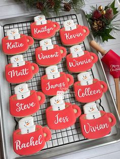 some cookies are on a cooling rack with red frosting and snowmen in them