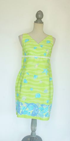 "This darling Lilly Pulitzer Maternity dress is perfect for summer.  It is sleeveless with an empire waist. The print is called \"low tide\" and features a wavy pattern of light and bright green with aqua and peach shells, with a five inch border of dark periwinkle crabs and fish and aqua and peach colored shells near the hem. There is a strip of white open cut lace at the empire waist. The dress is fully lined and made of 97% cotton with 3% spandex so it has a little stretch to it. The back has a 21 inch zipper and a 3 inch slit at the hem. Size Medium. *See measurements.    -Measurements:     -Bust: 36-37 inches     -Hips: 40 inches     -Length: 34 inches(measured from back of neck to hem) --------------------------------------------------------------------------------------------------- Green Sleeveless Knee-length Summer Dress, Green Knee-length Sleeveless Summer Dress, Beach Sundress With Lining, Beach Sundress Sleeveless And Lined, Summer Beach Dress With Empire Waist, Lined Sleeveless Sundress For Beach, Lined A-line Sleeveless Dress For Beach, Summer Vacation Dresses With Empire Waist, Green A-line Sleeveless Dress For Beach