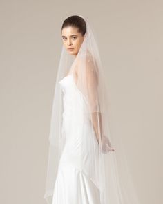 a woman in a white wedding dress and veil