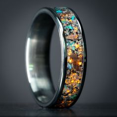 Discover the allure of our custom titanium band, featuring a mesmerizing Yooper Glow stone, Keweenaw Copper, and Opal inlay. Hand-harvested from unique stone fragments, known as Yooper Glow, these pieces boast an extraordinary secret. During the day, they present as ordinary lake stones, but under UV light, they reveal a mesmerizing, ember-like glow. Sourced directly from the beaches of Michigan’s Upper Peninsula, each piece is meticulously set by hand, ensuring durability and beauty that withst Opal Inlay Ring, Glow Ring, Glow Stones, Inlay Jewelry, Country Rings, Thick Ring, Beautiful Stones, Crushed Stone, Upper Peninsula