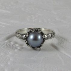 a ring with a black pearl in the center