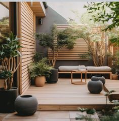 a wooden deck with potted plants and benches