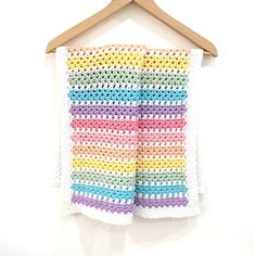 crocheted shorts hanging on a wooden hanger with a white wall in the background