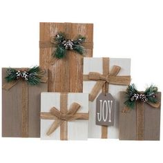 three wrapped gift boxes with bows and the word joy written on them, all tied together