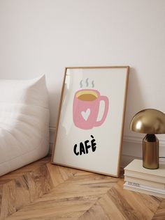 there is a framed coffee cup on the floor next to a lamp and bookshelf