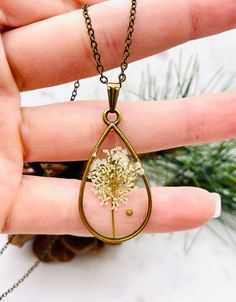 This beautiful teardrop floral mustard seed necklace is perfect for any occasion!  Share your faith and your love of nature everywhere you go. This beautiful handmade resin necklace makes the perfect gift for a loved one, a best friend, or just a reminder of your own inner beauty and faith.  Necklace is handmade with resin, real flowers, mustard seeds, and an antique bronze chain.  Chain Length: 18 inches long  Chain Width: 1.5 mm Antique Bronze chain with lobster clasp Please contact me if you have any questions or requests. Due to the handmade nature of the resin process no two necklaces will ever be exactly identical. Please keep in mind that there may be some minor imperfections in the resin, such as tiny air bubbles SHOP DESCRIPTION: Resin jewelry has endless possibilities and I love Mustard Seed Resin Jewelry, Handmade Teardrop Necklace For Her, Nature-inspired Teardrop Pendant Necklace For Gifts, Nature-inspired Teardrop Pendant Necklace As Gift, Handmade Teardrop Necklace As Gift For Her, Nature-inspired Teardrop Pendant Jewelry For Gifts, Nature-inspired Teardrop Pendant Jewelry Gift, Teardrop Pressed Flowers Jewelry Gift, Teardrop Necklace With Natural Inclusions For Gift