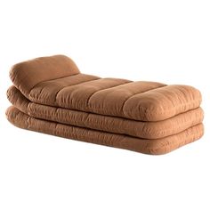 two brown mattresses stacked on top of each other in front of a white background