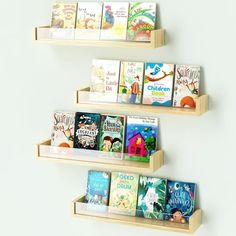 three wooden bookshelves are shown with children's books on them